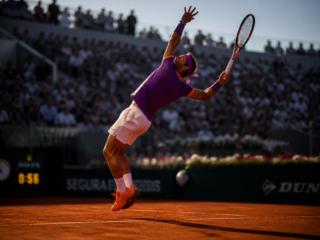 Wide low-angle photograph of a tennis server captured at full extension during the explosive…