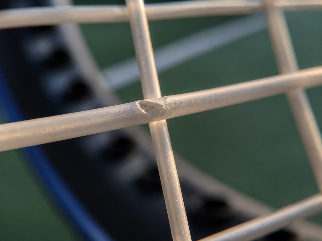 Extreme macro photograph of a tennis racquet's polyester string bed, focused tightly on the…