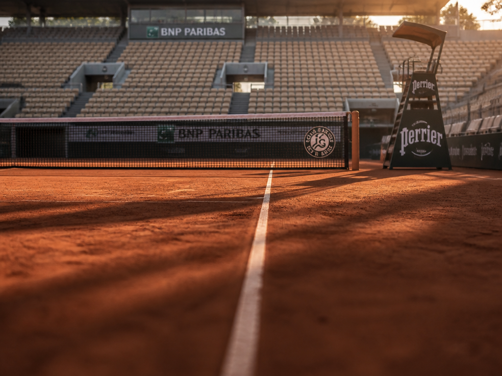 A pristine empty professional tennis court at a major tournament, viewed from a low…